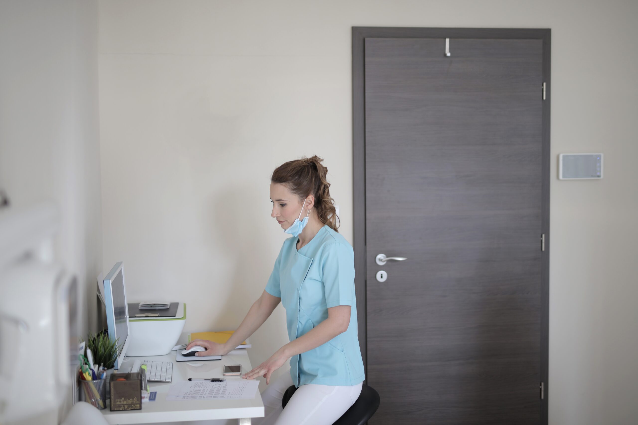 Young female doctor working with computer in modern clinic